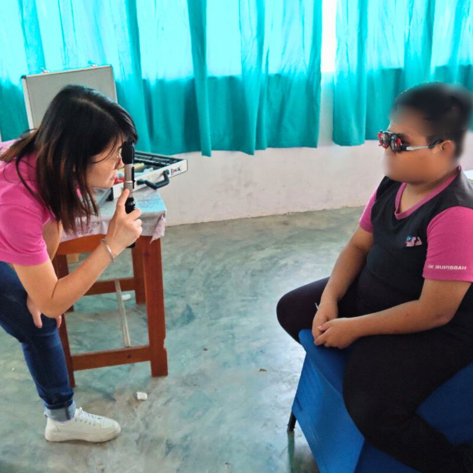 GHL Optical optician performing professional refraction test on student at SK Muhibbah