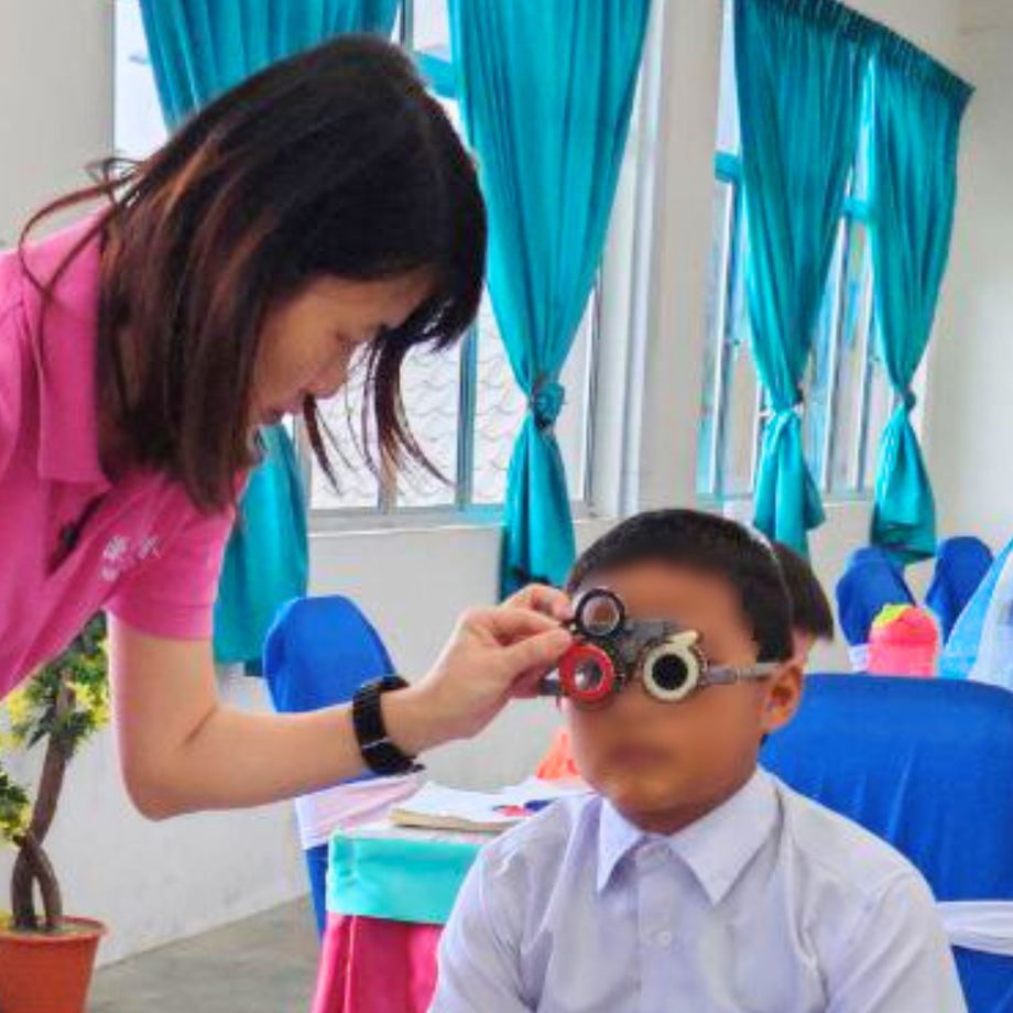 GHL Optical optician performing professional refraction test on student at SK Muhibbah