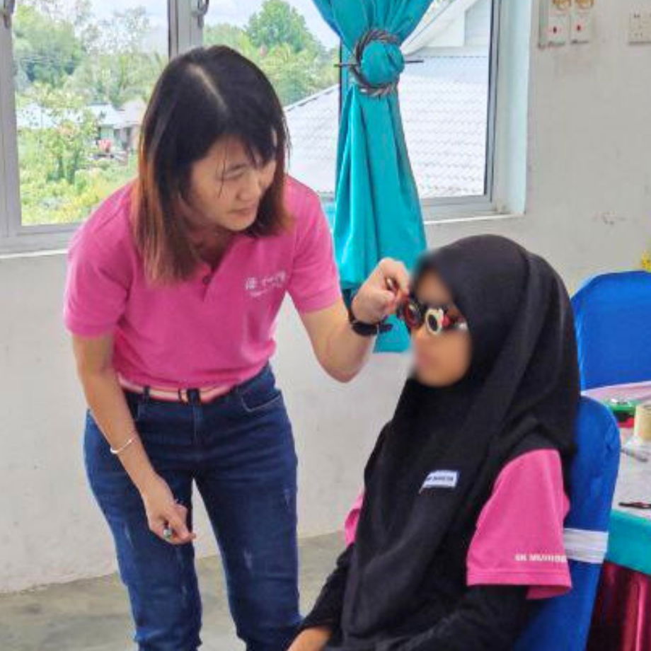 GHL Optical optician performing professional refraction test on student at SK Muhibbah