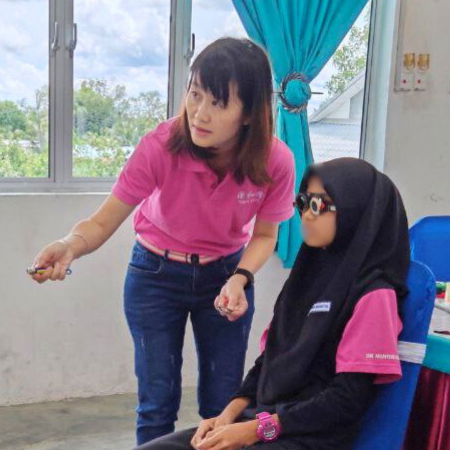 GHL Optical optician performing professional refraction test on student at SK Muhibbah